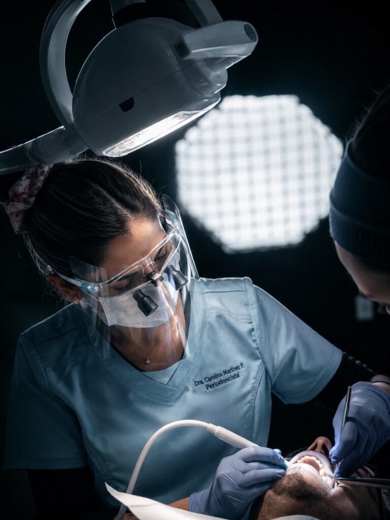 Profesional realizando un procedimiento dental con lupas