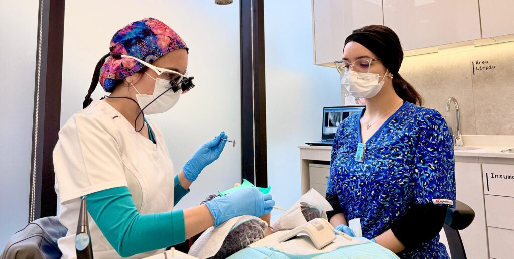 Profesionales de la clínica preparando un procedimiento junto a una paciente